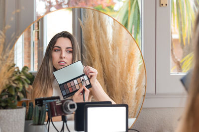 Portrait of young woman using mobile phone at home