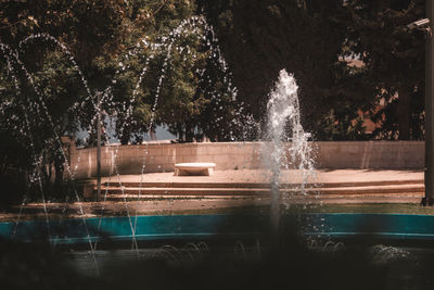 Fountain by swimming pool in park