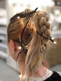 Close-up of woman with wearing illuminated string light in braided hair