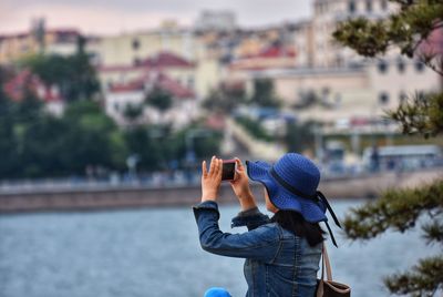 Rear view of man using mobile phone in city