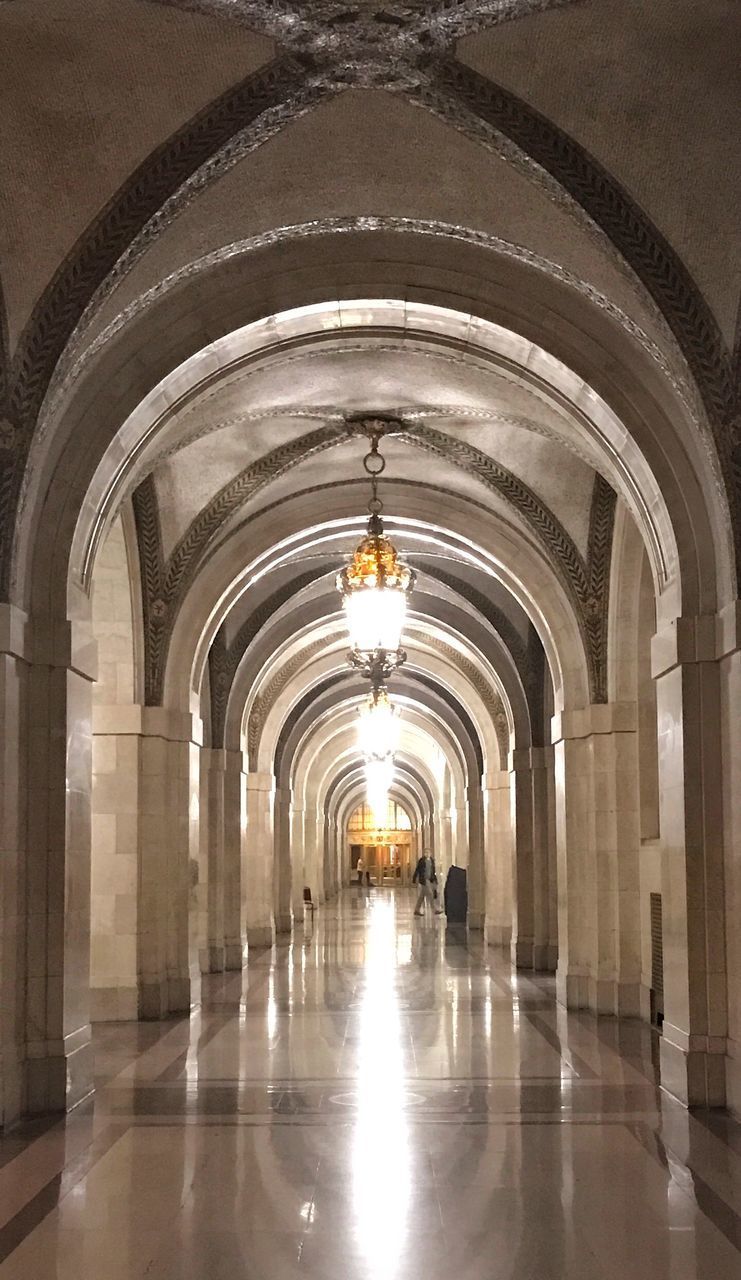 INTERIOR OF ILLUMINATED EMPTY CORRIDOR OF BUILDING