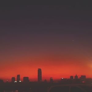 Illuminated cityscape against sky at night