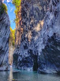 Rock formation in sea against sky