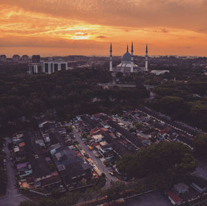 Aerial view of buildings in city during sunset