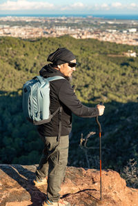 Middle-aged man contemplates the landscape of the garraf natural park, from the top of the mountain.