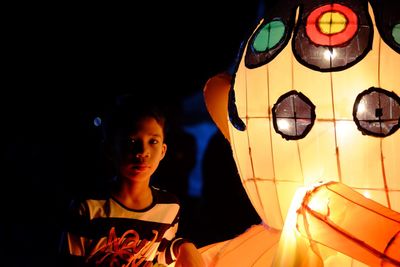 Full length of girl in illuminated lantern at night