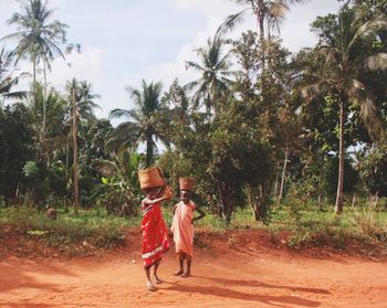 Girl playing with palm trees against sky