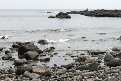 Rocks in sea against sky