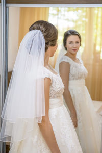 Bride looking in mirror at home