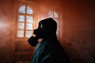 Side view of man photographing through window