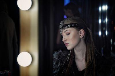 Portrait of beautiful young woman looking away at night