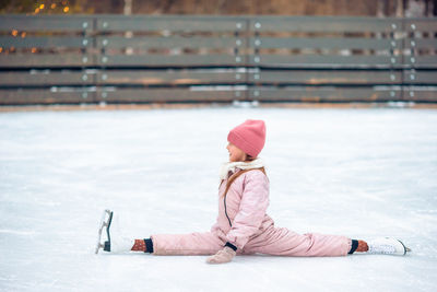 Girl with pink umbrella on snow during winter