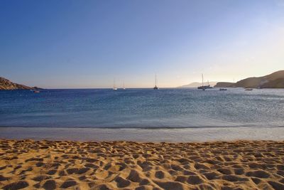 Scenic view of beach against clear sky during sunset