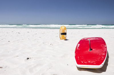 Surfboard on beach against clear sky