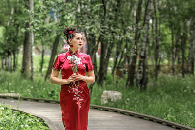 Portrait of smiling young woman standing in forest