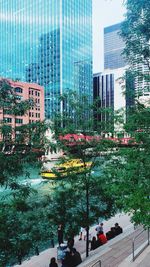 People by swimming pool against buildings in city