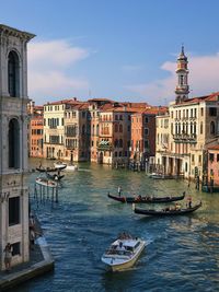 Canal in city against sky