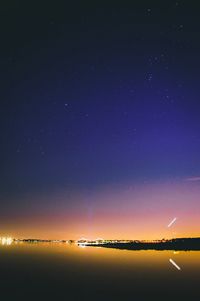 Scenic view of lake against sky at night
