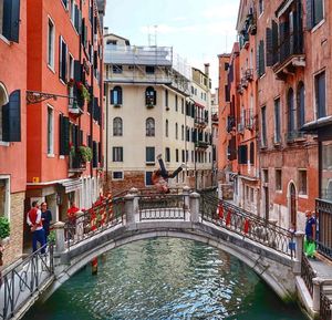 Bridge over canal amidst buildings in city