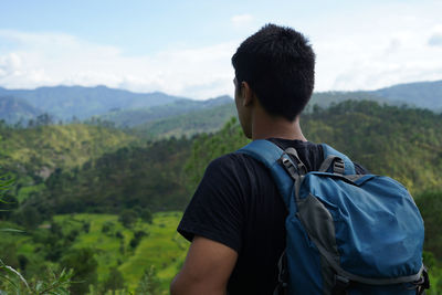 Rear view of man looking at mountains