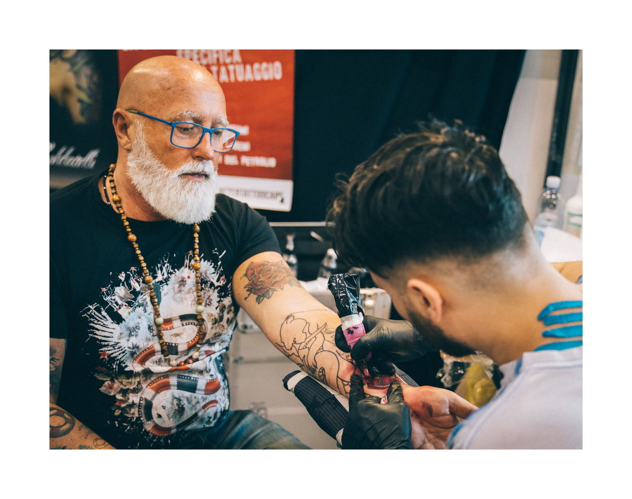 transfer print, men, real people, glasses, eyeglasses, males, indoors, auto post production filter, two people, adult, lifestyles, holding, people, casual clothing, family, sitting, customer, beard, tattoo, facial hair
