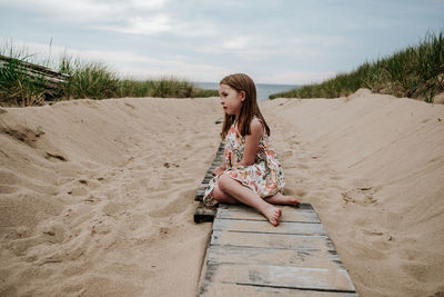 Full length of woman sitting on beach