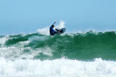 Man surfing at sea against clear sky