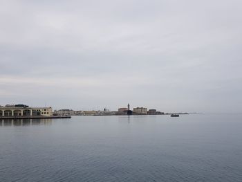 Scenic view of sea by buildings against sky
