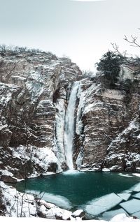 Scenic view of waterfall against sky during winter