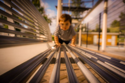 Cute boy playing on bench