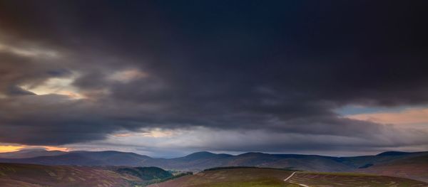 Scenic view of mountains against cloudy sky