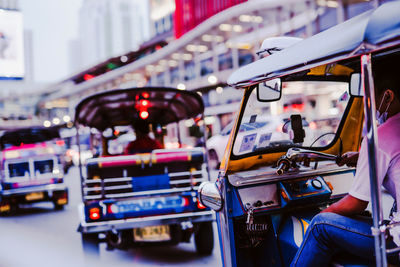 Rear view of driver people in local taxi call tuk tuk of thailand on street in city