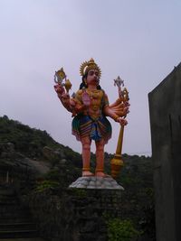 Statue against temple and building against sky