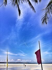 Low angle view of flag on beach against sky