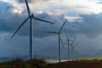 Low angle view of windmill on field against sky