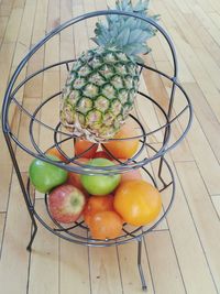 High angle view of fresh fruits on metallic rack on hardwood floor at home