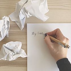 Close-up of hand holding paper on table