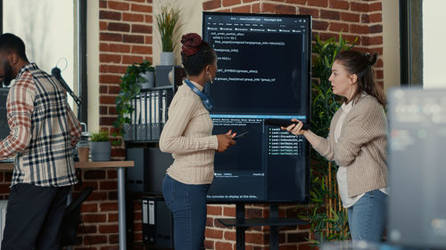 Rear view of woman using digital tablet in office