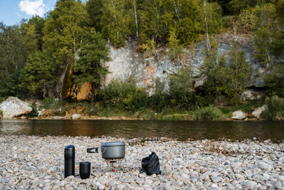 Garbage can on rock by river