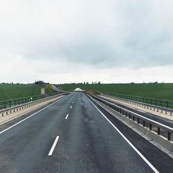 Empty road against cloudy sky