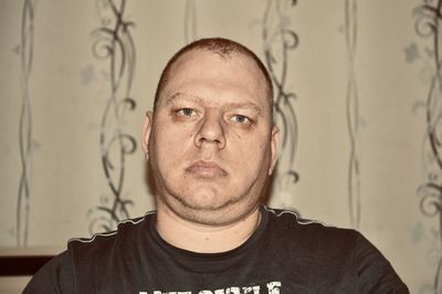 Portrait of young man against wall at home