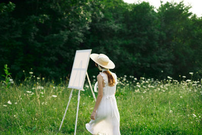 Woman holding umbrella on field