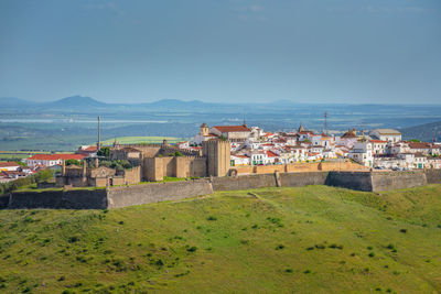 High angle view of townscape by sea against clear sky