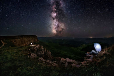 Scenic view of landscape against sky at night