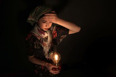 High angle view of woman holding illuminated lantern