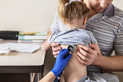 Little girl  in the doctor's office.the doctor listens to the lungs with a phonendoscope.