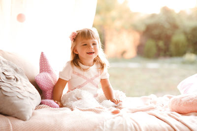 Playful girl sitting on bed at park