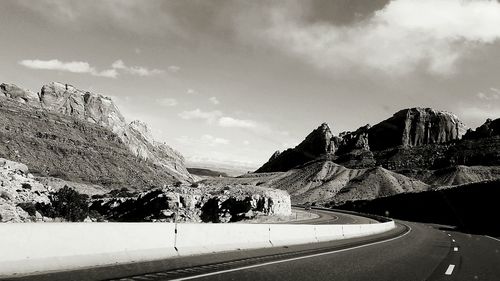 Road by mountain against sky