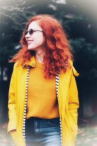 Beautiful young woman with yellow hair standing outdoors