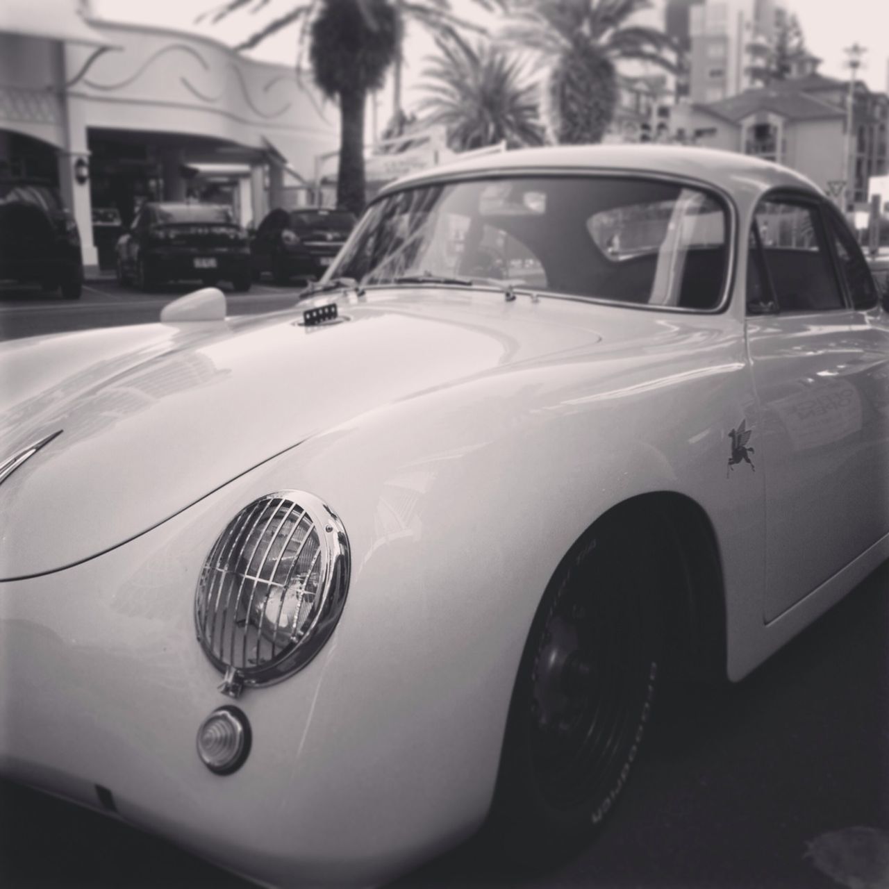 transportation, mode of transport, land vehicle, car, stationary, street, headlight, glass - material, reflection, travel, transparent, vehicle, window, city, focus on foreground, vintage car, road, day, on the move, close-up